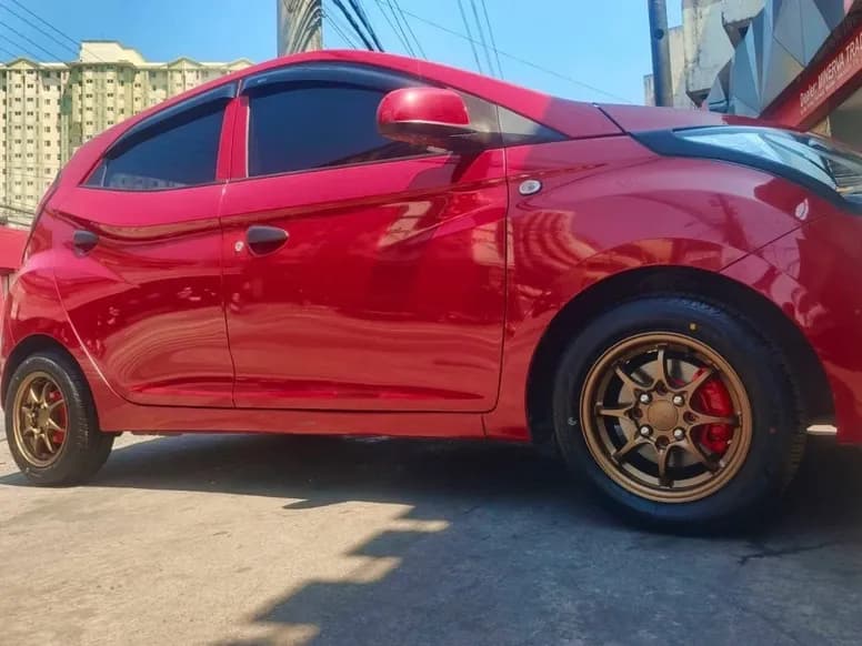 Red Hyundai Eon on bronze mags