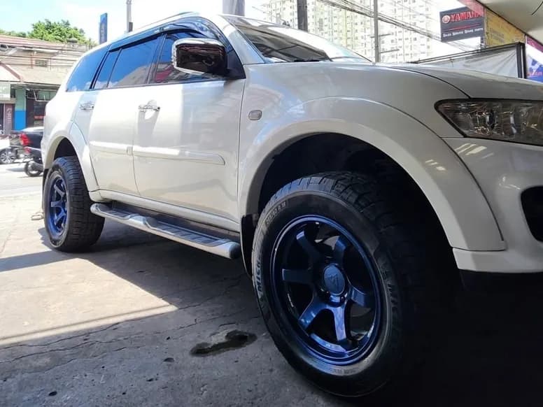 White Montero Sport on blue off-road mags outside the shop